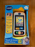 VTech Touch & Swipe Baby Phone in original packaging showing front view with colorful touch screen display and product details.