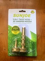 Front of sealed Sun Joe 2-in-1 Twist Hose and Jet Sweeper Nozzle package showing product and branding.