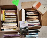 Two cardboard boxes filled with books mostly theatrical plays and classic literature, some showing wear and damage on the covers