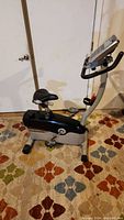 Side view of the Schwinn electronic exercise bike showing seat, pedals, frame, and digital console.