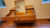 Fold-down mirror open, top drawer compartment with divider sections, lower drawers visible