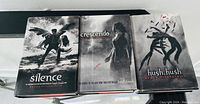 Photo showing three hardcover Becca Fitzpatrick books: Silence, Crescendo, and Hush, Hush with dust jackets visible.