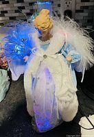 Photo of light up angel Christmas figurine with blue and white dress, feather wings, and internal LED lights.