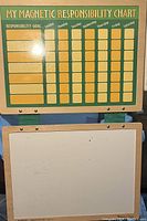 Front view of the magnetic responsibility chart with labeled grid columns for days of the week and a whiteboard section below.
