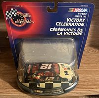 Full view of the sealed NASCAR 1:43 scale Victory Celebration diecast collectible model in original packaging showing car number 12 with Mobil 1 sponsorship and accompanying victory celebration figurine.