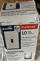 Photo of the box showing 10-pack of Leviton unbreakable nylon wall plates in white, medium size, preferred series.