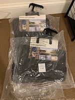 Two packages of floor mats sealed in plastic with BMW labeling visible, showing brand new condition.