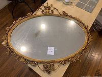 Full top-down view of the oval mirror on table showing overall frame and glass surface.