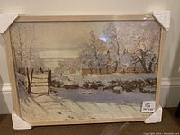 Full view of the framed print of Monet's 'The Magpie' wrapped in plastic with corner protectors on the frame.
