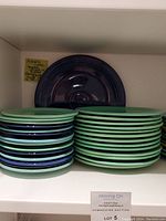 Stacks of small and medium Fiesta plates with one cobalt blue platter at back