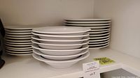 Stacks of bowls and plates together on shelf