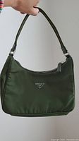 Front and side view of small olive green Prada nylon shoulder bag with triangular logo plaque and single strap