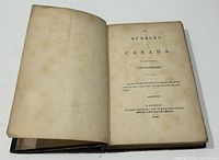 Photo of the open book showing title page with publication details: 'The Bubbles of Canada' by Thomas Chandler Haliburton, published by Richard Bentley, London, 1839.