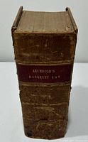 Front spine of the book showing the title 'Archbold's Bankrupt Law' on a red label with visible age wear and cracking on the leather spine.