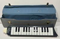 Open case displaying the Hohner Melodica Piano 26 keyboard with 26 keys inside the blue interior lining.