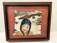 Framed painting on birch bark of a First Nations girl with braided hair, full artwork visible, showing natural birch bark texture and frame.