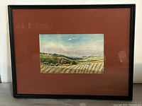 Framed watercolour landscape painting with reddish-brown matte, showing the full art piece and frame.