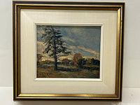 Full view of the framed painting showing gold frame and linen mat surrounding landscape