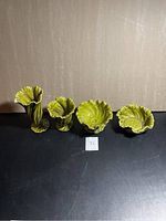 Four green ceramic Brody Sea Mist vases arranged in a row showing their shape and size