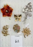 Top view of all six floral brooches showing front details and colors