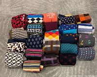 Full lot of 24 colorful socks showing a variety of patterns and colors