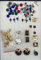 Top view of colorful collar stays and various cuff links arranged on a display board.