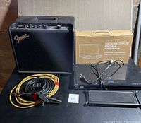Fender Mustang LT25 amplifier with cables, DBPower portable DVD player in original box, Panasonic Blu-ray player, and On Stage foot rest displayed together.