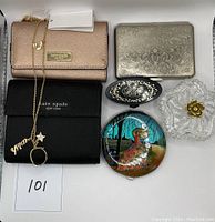Photo showing the three Kate Spade items and additional decorative objects including trinket boxes and compact
