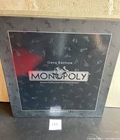 Front of the Monopoly Onyx Edition box showing the logo and embossed token pattern