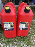 Front view of two red 20L gas cans side by side with visible labels and caps.