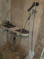 Full view of ironing board with electric iron, hose, and Jiffy handheld steamer on stand