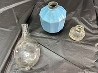 Overview of three vintage glass items including blue milk glass lightning rod ball, clear glass infant feeder, and small glass inkwell.