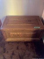 Front view of solid wood chest with panel detail on top and front.