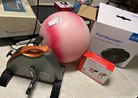Photo showing the Renpho foot massager box, pink fitness ball, foot roller in packaging, and Marcy foot pedal exerciser.