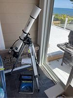 Photo of Meade Model 390 refracting telescope with tripod setup indoors near a window.