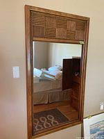 Full view of the rectangular wall mirror showing the entire frame and reflection.