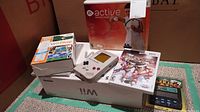 All items together: Nintendo Wii console box with controllers, Game Boy DMG-01, Kidz Sports Ice Hockey Wii game, Wii Play game box, Wii Active Personal Trainer game box, and Black Jack 21 electronic game in sealed packaging.