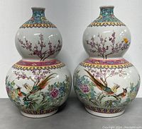 Front view of both vases showing bird and floral decoration