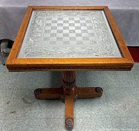 View of the table top showing the reversible etched glass checkerboard and floral design framed in oak.