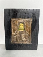 Front view of antique Russian silver icon of Jesus Christ Pantocrator mounted on a rectangular wooden plaque with dark finish. Shows icon details and wood grain.
