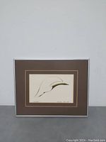 Framed matted art print showing the entire piece including frame and matting, featuring an abstract bird drawing.