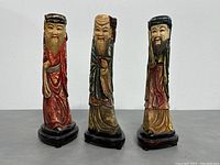 Front view of the three Fu, Lu, Shou Chinese gods hand painted wooden figurines on individual black bases.