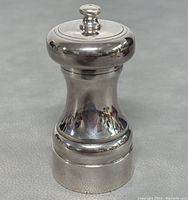 Front and side view of the polished sterling silver pepper grinder showing overall shape and design.