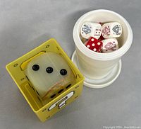 View showing the poker dice in a white container and the large onyx dice in its yellow box.