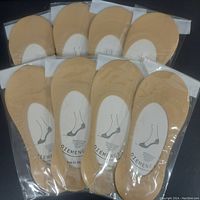 Eight pairs of beige nylon sockettes in individual clear plastic packages, displayed on a black surface.