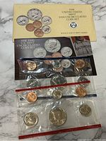 Photo showing two sealed sets of 1990 Uncirculated United States Mint coin sets with both Denver (D) and Philadelphia (P) mint marks in original packaging.