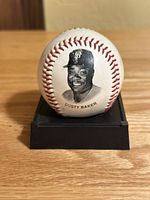 Front view of Dusty Baker collectible baseball showing black-and-white image of Dusty Baker in Giants cap with text beneath.