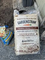 Photo of packaged bag labeled GardenStraw Sustainable Mulch by Healthistraw showing coverage details and branding.