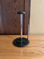 Front and left side views of green marble paper towel holder with metal rod and side bar.