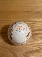Nolan Ryan commemorative baseball honoring 1966 to 1993 inside clear display case on wooden surface.